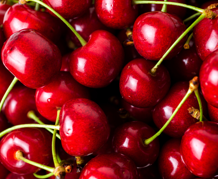 Red ripe delicious cherries background.