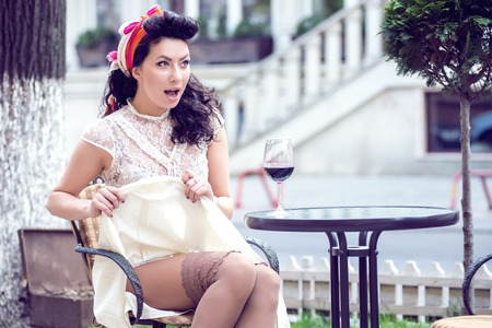 Young Italian woman drinking red wine in an outdoor cafe.の写真素材