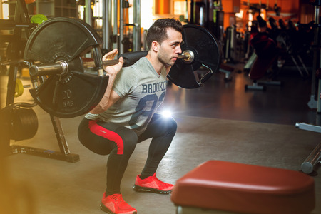 Young bodybuilder doing weight lifting in gymの写真素材