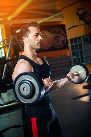 Young bodybuilder doing weight lifting in gymの写真素材