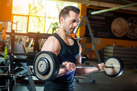 Young bodybuilder doing weight lifting in gymの写真素材