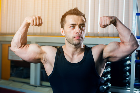 Strong Athletic Man showing muscles in gym.の写真素材