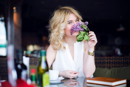 Successful and wealthy business woman having cup of espresso coffee while sitting in a restaurant terrace.の写真素材