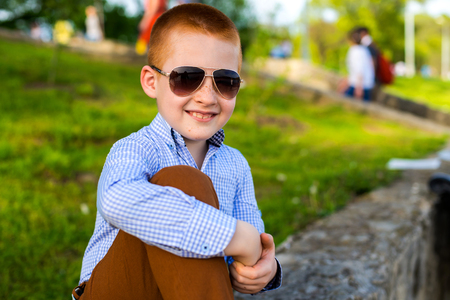 Stylish baby boy with ginger hair in trendy sunglasses.の写真素材