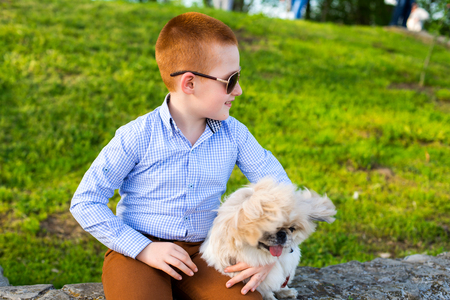 Baby boy lovingly embraces his pet dog.の写真素材