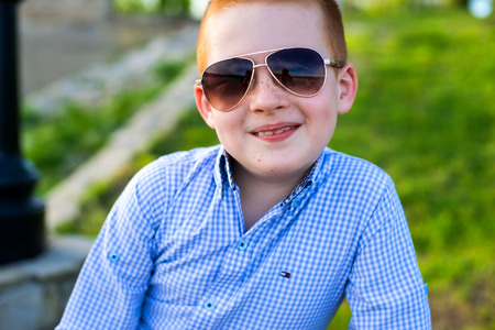 Stylish baby boy with ginger hair in trendy sunglasses.の写真素材