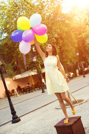 Happy young woman with colorful latex balloons, outdoor.の写真素材