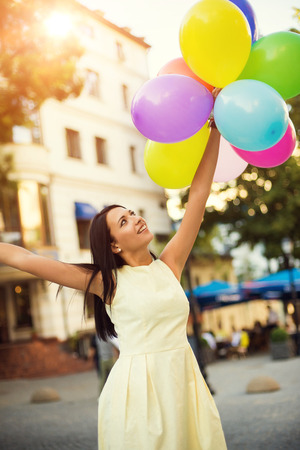 Happy young woman with colorful latex balloons, outdoor.の写真素材