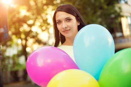 Happy young woman with colorful latex balloons, outdoor.の写真素材