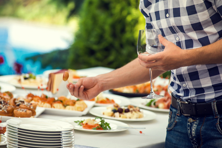 Men's hand holding wine glass at festive event,の写真素材