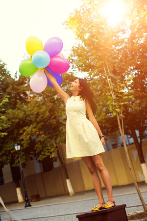 Happy young woman with colorful latex balloons, outdoor.の写真素材