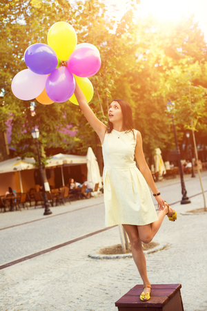 Happy young woman with colorful latex balloons, outdoor.の写真素材