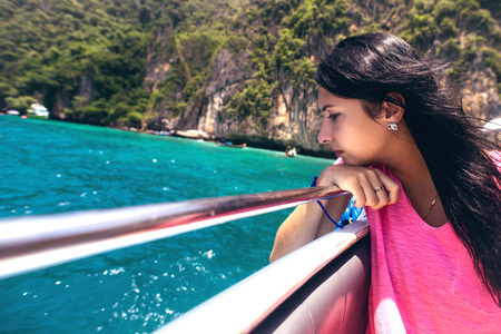 Woman on the boat floating near the island.の写真素材