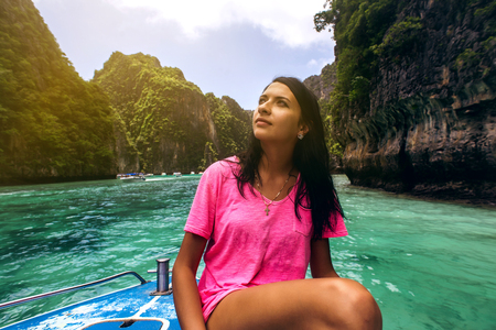 Woman on the boat floating near the island.の写真素材