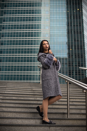 Pretty girl with long hair poses in the city streets.の写真素材