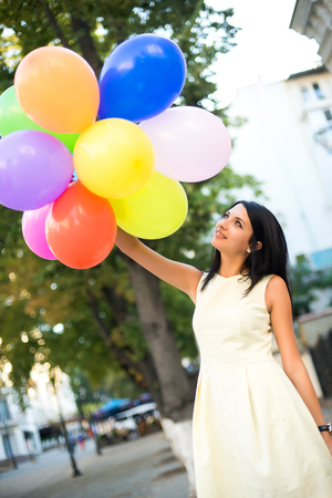 beautiful woman with colorful balloons in the city.の写真素材