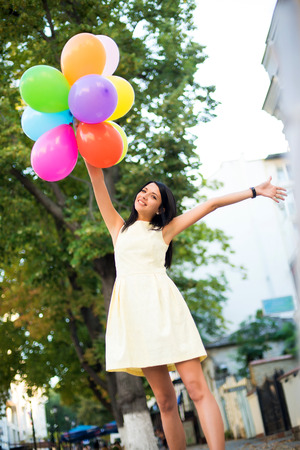 beautiful woman with colorful balloons in the city.の写真素材