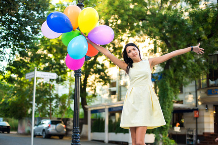 beautiful woman with colorful balloons in the city.の写真素材