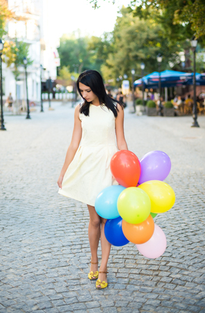 beautiful woman with colorful balloons in the city.の写真素材