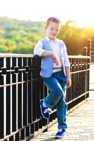 Stylish baby boy with ginger hair in trendy sunglasses.の写真素材