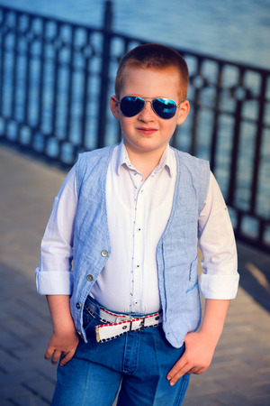 Stylish baby boy with ginger hair in trendy sunglasses.の写真素材