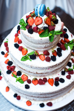 wedding cake with layers placed on a table in a restaurant in the chamber, variety of fruits and berries.の写真素材