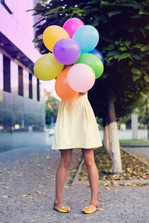 beautiful woman with colorful balloons in the city.の写真素材