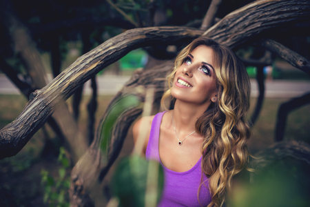 Sexy woman in purple dress against nature park backgroundの写真素材