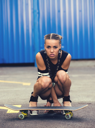 Beautiful and sexy girl sitting on the skateboard.の写真素材