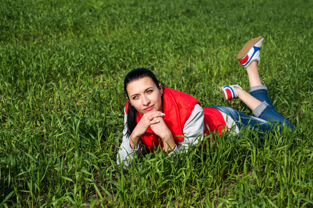 young, attractive woman relaxing on green grassの写真素材