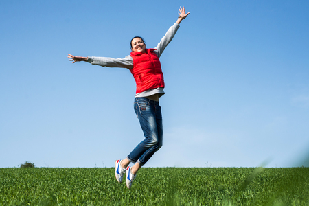 woman jumping funny relax on green grassの写真素材