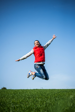 woman jumping funny relax on green grassの写真素材