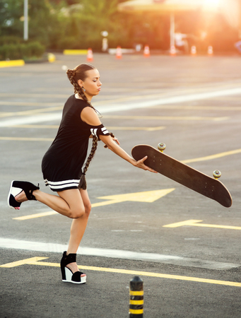 young pretty girl using skateboard on the street, hipster style, outdoor beauty portrait,の写真素材