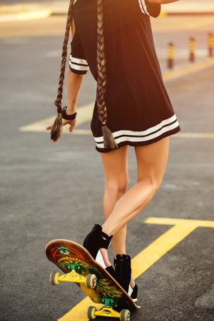 young pretty girl using skateboard on the street, hipster style, outdoor beauty portrait,の写真素材