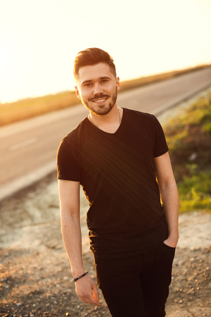 casual young man standing outdoor and smiling for the camera.の写真素材