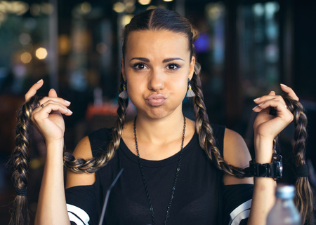 Cute girl teenager with two pigtails hair braids posing for cameraの写真素材