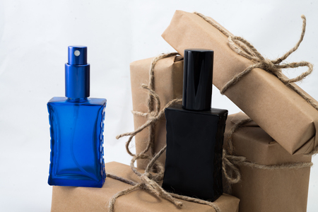 Stack of handcraft gift boxes nad parfume glasses on white background.の写真素材