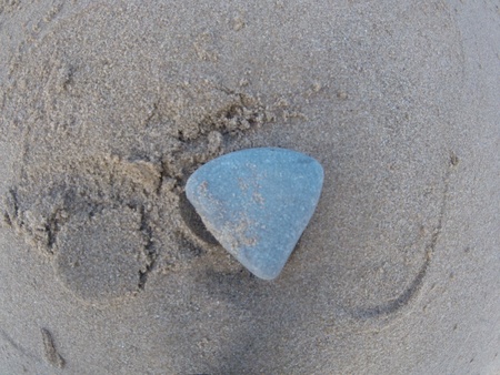 A single pebble at the beach in beautiful sand