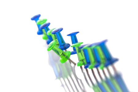 Pins on a curved line, one pin stands outの写真素材