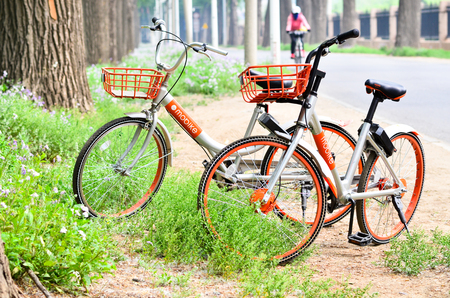 Beijing,China-April 2017-one orange color bicycles called mobike shareing bicycle beside the wild road in Beijing of china.のeditorial素材