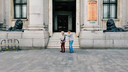 An elderly couple walking in front of the museumのeditorial素材