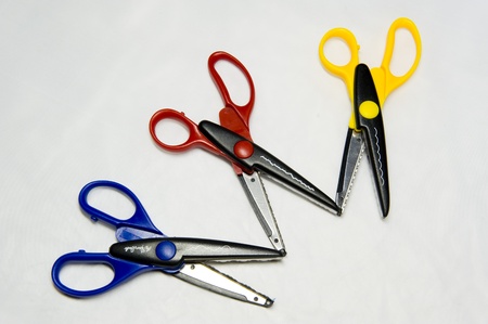 Three pairs of scissors with different colored handles provide choicesの写真素材