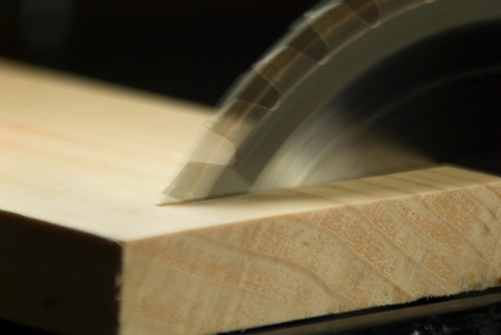 Circular Saw blade making a Cross Cut through a boardの写真素材