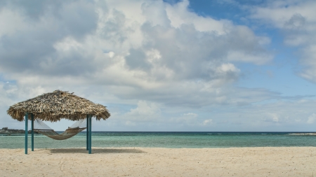 hammock and tiki hut on beach in Bahamasの写真素材