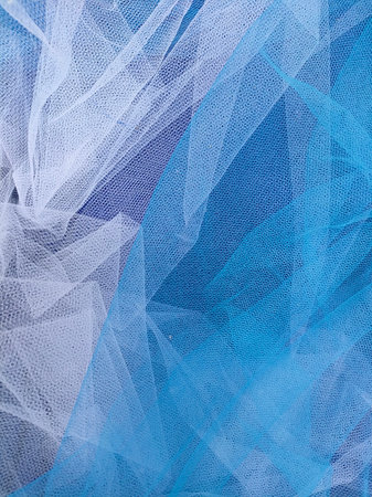 blue tulle as a background, close up view of the fabricの写真素材
