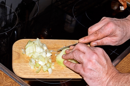 Chef slicing Onion, Allium cepa on the cutting board with a knife.の写真素材