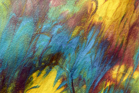 Macro shot of a mix of acrylic paint and oil on a marbled paper background