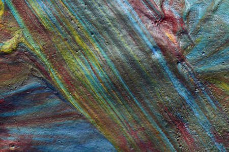 Macro shot of a mix of acrylic paint and oil on a marbled paper background.