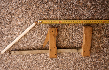 A wooden plate with various tools, wooden quick clamp, pencil, measuring tapeの写真素材
