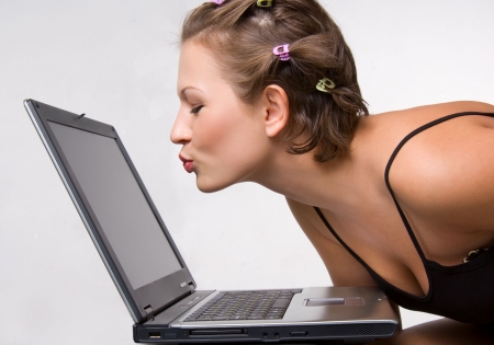 Pretty caucasian female kissing laptop screenの写真素材